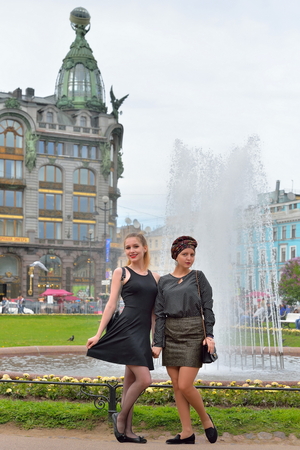 Girls tourists are at the fountain House in the background of the book - singer on Nevsky prospect in Saint-Petersburgの写真素材