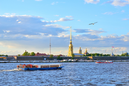 Tourist boats on the Neva river on the background of the fortress summer evening in Saint-Petersburg.の写真素材