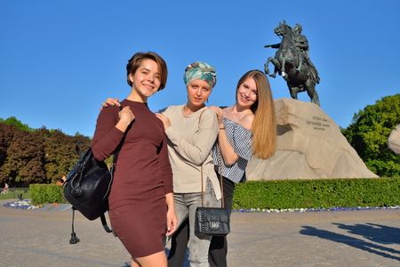 Three young girls are photographed on the background of the monument bronze Horseman in Saint-Petersburg.の写真素材