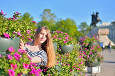 A young girl at the flower beds on the background of the monument bronze Horseman in Saint-Petersburg.の写真素材