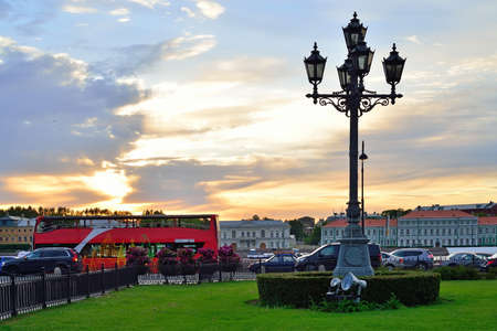 Vintage street lantern and a red tourist bus at sunset in Saint-Petersburgの写真素材