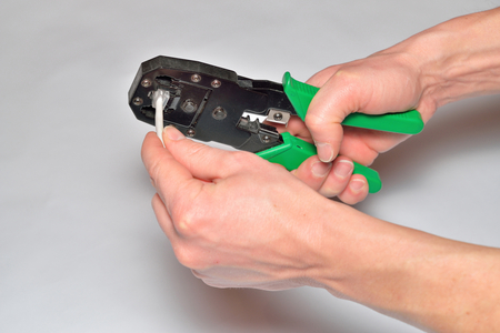 Hands of the installer, computer network, fix the connector on the cable.の写真素材