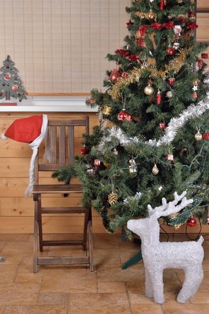 A chair and a statue of a deer near the Christmas tree.の写真素材