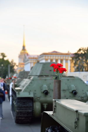 Red flowers in a gun cartridge on a medium Soviet tank T-34 on the background of the Admiralty and walking peopleの写真素材