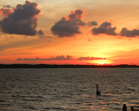 Bright sunset over water with pylansの写真素材