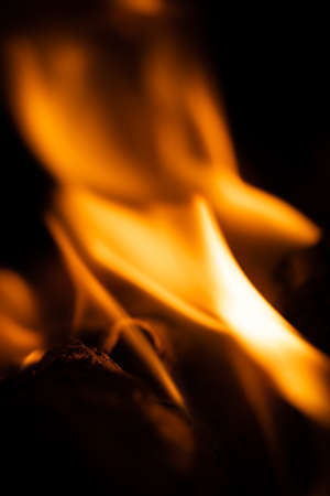Fire close-up and red orange yellow color detail texture and abstract shape on black backgroundの写真素材