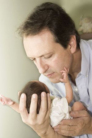 Portrait of family, father playing with his newborn baby