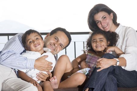 Portrait of family, mom and dad playing with their children at homeの写真素材
