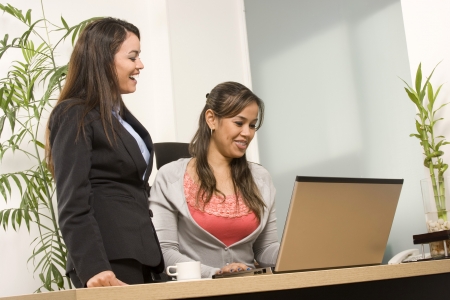 Two Businesswoman working together on laptop in officeの写真素材