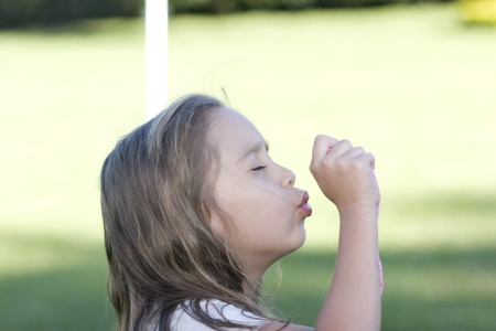 Portrait Of Lovely Little Girl Blowing Soap Bubblesの写真素材