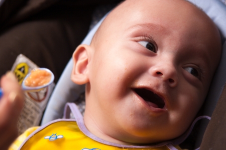 Portrait of a Mother Feeding Her Sweet Baby Boy, With Spoonの写真素材