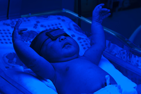 Portrait of newborn baby sleeping inside incubatorの写真素材