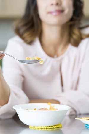 Attractive woman having breakfast in kitchen interiorの写真素材