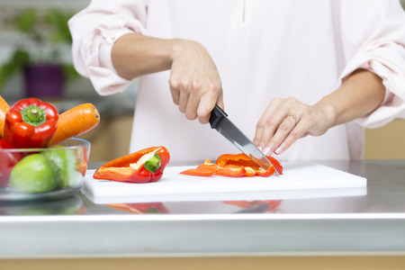Closeup on woman cutting fresh vegetables in kitchenの写真素材