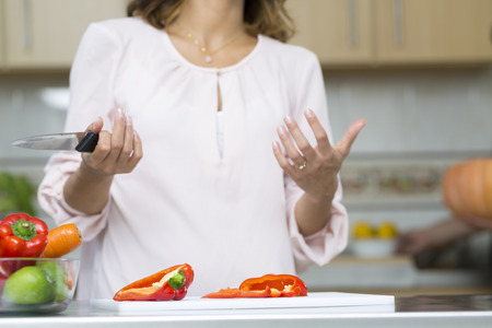 Closeup on woman cutting fresh vegetables in kitchenの写真素材