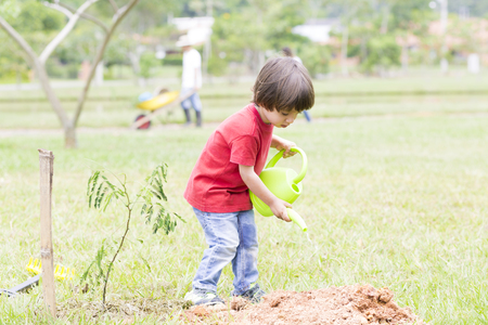 Portrait of Lovely Boy Watering Plants Outdoorsの写真素材