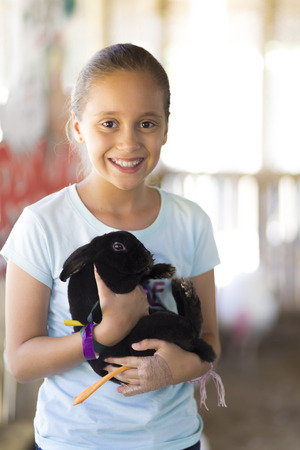 Happy Girl Playing with Rabbit in the Farmの写真素材