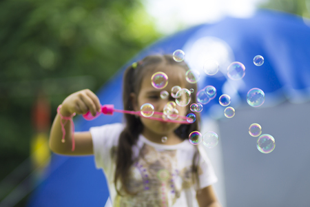 Happy Girl Playing with Soap Bubblesの写真素材