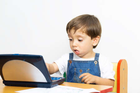 Happy Boy Sitting at his Desk With Laptop Computerの写真素材