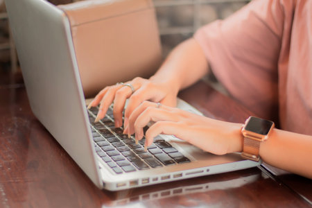 Hands close up of businesswoman working on laptop on table in cafe, looking freelance and typing in notebook on table, lifestyle of woman studying online, business concept.の写真素材
