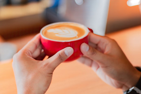 Female hands holding cup of coffee on table bar. perspective view. coffee shop.