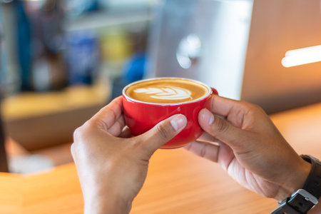 Female hands holding cup of coffee on table bar. perspective view. coffee shop.の写真素材