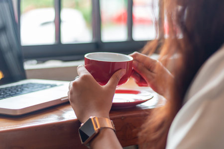young asian woman holding a cup of coffee and break. Beautiful young asian businesswoman in cafe,...
