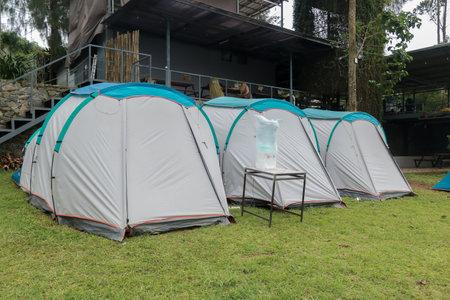 Camping and tent in the riverside. Panoramic landscape. Natural area with trees and green grass. Camping tent. Camping areaの写真素材