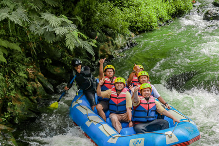 Pangalengan, Bandung-Indonesia December 2022 : A group of men and women are rafting on the river, extreme and fun sport. Group of people water sport raftingのeditorial素材