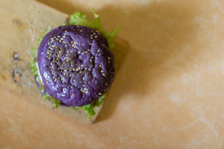 close up photo of a home-made purple burger placed on a ceramic table. Hamburger. Fast Food. Culinaryの写真素材