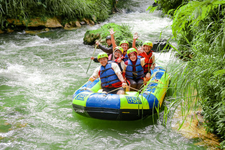 Pangalengan, Bandung-Indonesia December 2022 : A group of men and women are rafting on the river, extreme and fun sport. Group of people water sport raftingのeditorial素材