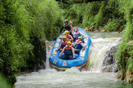 Pangalengan, Bandung-Indonesia December 2022 : A group of men and women are rafting on the river, extreme and fun sport. Group of people water sport raftingのeditorial素材