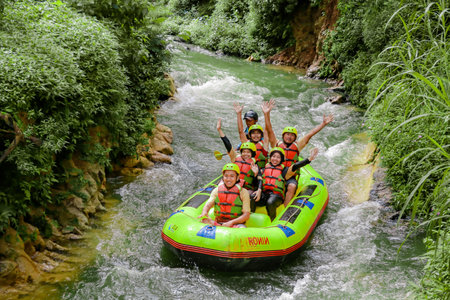 Pangalengan, Bandung-Indonesia December 2022 : A group of men and women are rafting on the river, extreme and fun sport. Group of people water sport raftingのeditorial素材