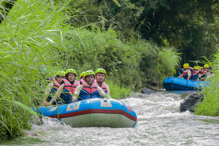Pangalengan, Bandung-Indonesia December 2022 : A group of men and women are rafting on the river, extreme and fun sport. Group of people water sport raftingのeditorial素材