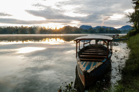 photo of dramatic sunrise view on the lake. with the boat being the foreground. Landscape. Nature.の写真素材