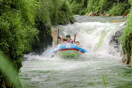 Pangalengan, Bandung-Indonesia December 2022 : A group of men and women are rafting on the river, extreme and fun sport. Group of people water sport raftingのeditorial素材