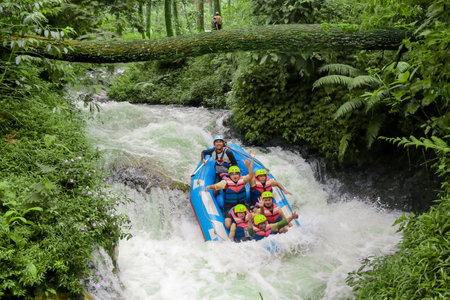 Pangalengan, Bandung-Indonesia December 2022 : A group of men and women are rafting on the river, extreme and fun sport. Group of people water sport raftingのeditorial素材
