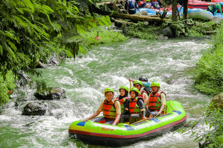 Pangalengan, Bandung-Indonesia December 2022 : A group of men and women are rafting on the river, extreme and fun sport. Group of people water sport raftingのeditorial素材