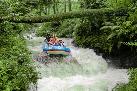Pangalengan, Bandung-Indonesia December 2022 : A group of men and women are rafting on the river, extreme and fun sport. Group of people water sport raftingのeditorial素材