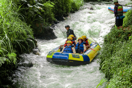 Pangalengan, Bandung-Indonesia December 2022 : A group of men and women are rafting on the river, extreme and fun sport. Group of people water sport raftingのeditorial素材