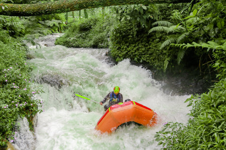 Pangalengan, Bandung-Indonesia December 2022 : A group of men and women are rafting on the river, extreme and fun sport. Group of people water sport raftingのeditorial素材