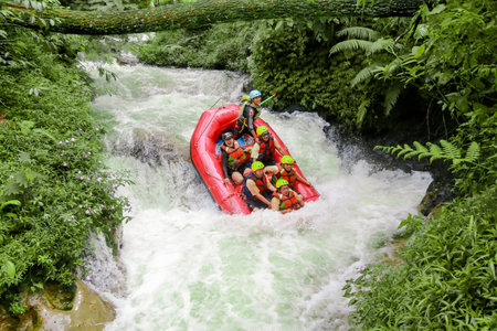Pangalengan, Bandung-Indonesia December 2022 : A group of men and women are rafting on the river, extreme and fun sport. Group of people water sport raftingのeditorial素材