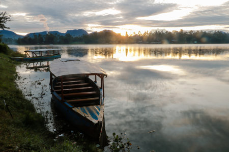 photo of dramatic sunrise view on the lake. with the boat being the foreground. Landscape. Nature.の写真素材