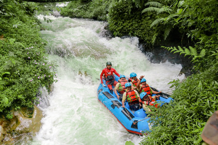 Pangalengan, Bandung-Indonesia December 2022 : A group of men and women are rafting on the river, extreme and fun sport. Group of people water sport raftingのeditorial素材