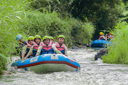 Pangalengan, Bandung-Indonesia December 2022 : A group of men and women are rafting on the river, extreme and fun sport. Group of people water sport raftingのeditorial素材