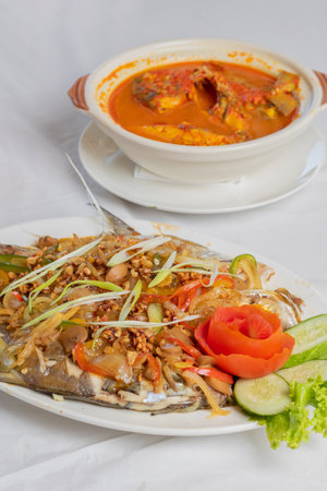 steamed pompano or kuwe fish with sweet and spicy sauce and beautiful garnishesの写真素材