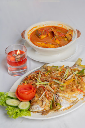 steamed pompano or kuwe fish with sweet and spicy sauce and beautiful garnishesの写真素材