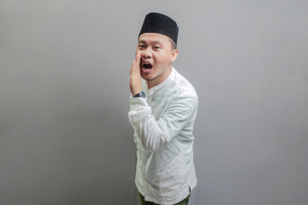 Happy asian muslim man hand on mouth telling secret rumor, whispering malicious talk conversation...