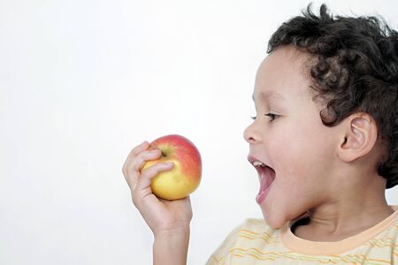 little boy eating apple with white background stock photoの写真素材