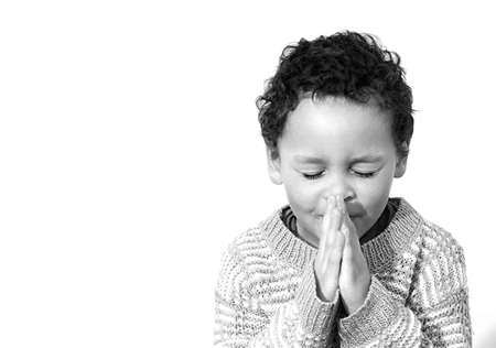 little boy praying with hands together on white background stock photo
